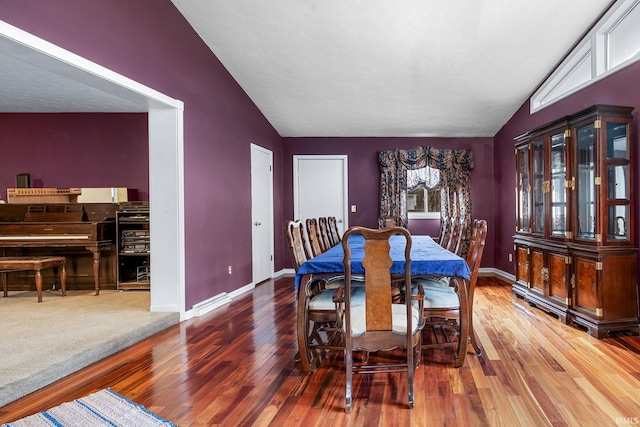 dining room with hardwood / wood-style flooring and vaulted ceiling