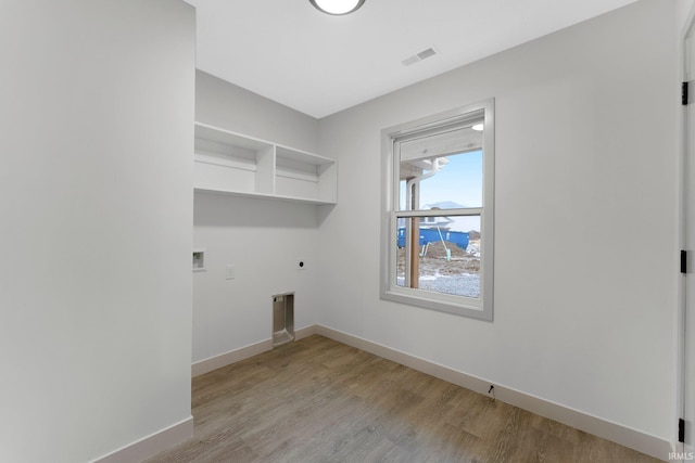 washroom with washer hookup, hookup for an electric dryer, and light hardwood / wood-style flooring