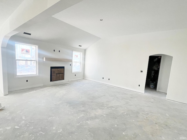 unfurnished living room featuring vaulted ceiling