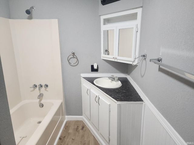 bathroom with shower / washtub combination, hardwood / wood-style floors, and vanity