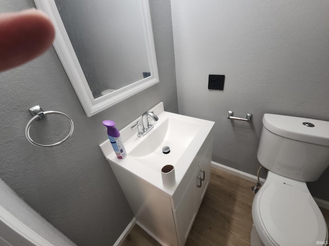 bathroom with wood-type flooring, vanity, and toilet