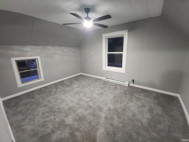 additional living space with ceiling fan, vaulted ceiling, dark carpet, and a baseboard heating unit