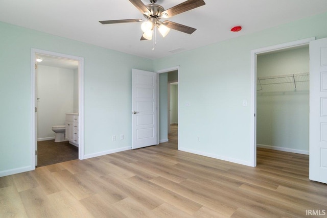 3711 Kansas Rd, Evansville, IN 47725 - unfurnished bedroom featuring light wood finished floors, a spacious closet, ensuite bath, a closet, and a ceiling fan
