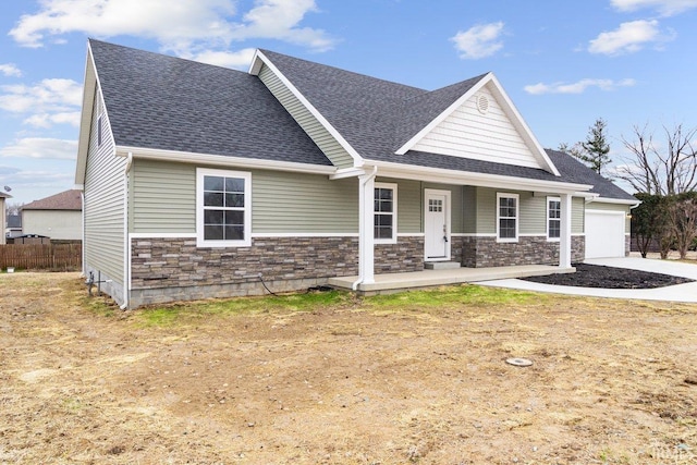 3711 Kansas Rd, Evansville, IN 47725 - craftsman house with a shingled roof, stone siding, covered porch, driveway, and a garage