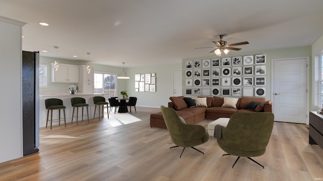 living room featuring light hardwood / wood-style flooring and ceiling fan