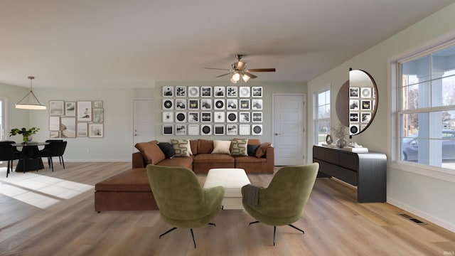 living room featuring ceiling fan and light hardwood / wood-style floors