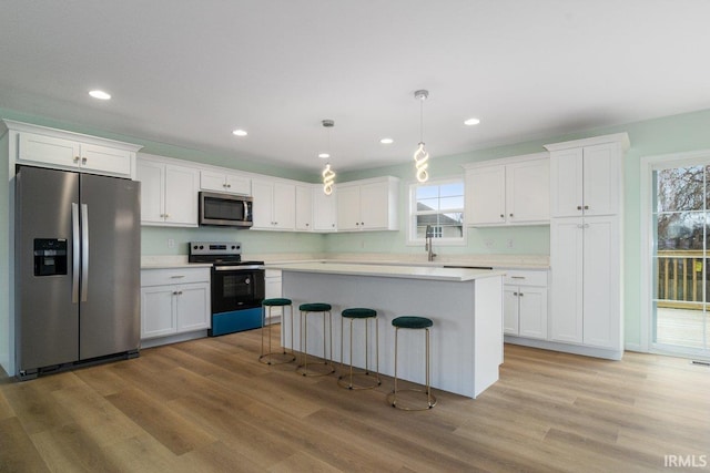 3711 Kansas Rd, Evansville, IN 47725 - kitchen featuring appliances with stainless steel finishes, light countertops, white cabinetry, light wood finished floors, and recessed lighting