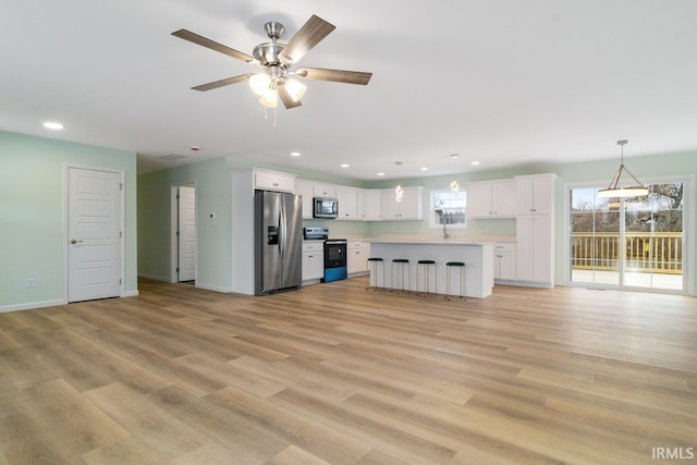 3711 Kansas Rd, Evansville, IN 47725 - kitchen with stainless steel appliances, open floor plan, white cabinetry, light countertops, and recessed lighting
