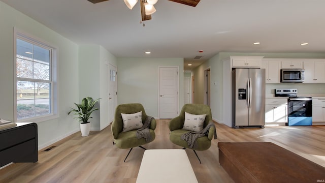 living area featuring ceiling fan and light wood-type flooring