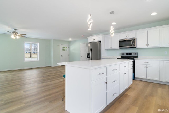 3711 Kansas Rd, Evansville, IN 47725 - kitchen with appliances with stainless steel finishes, a center island, light countertops, white cabinetry, and light wood-style floors