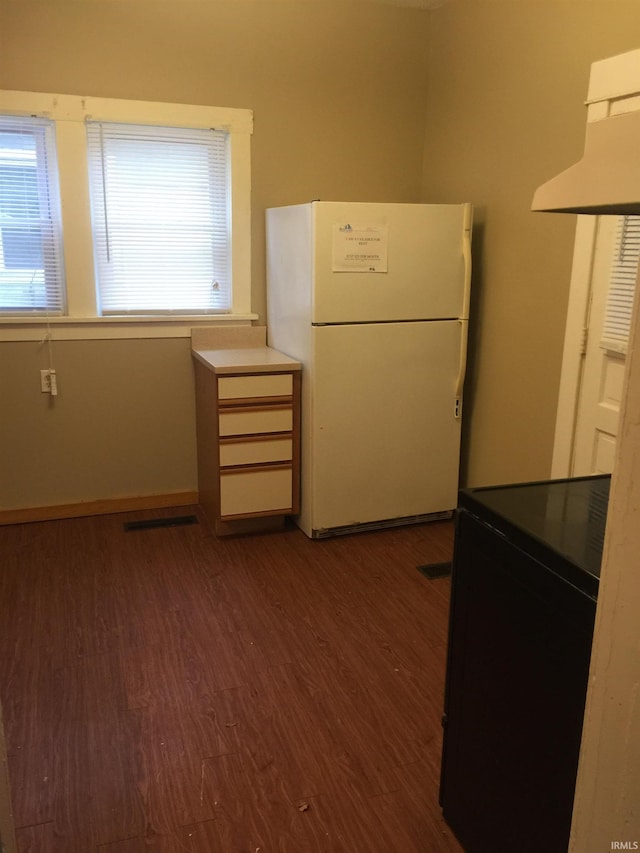 kitchen with white refrigerator, black electric range oven, dark wood-type flooring, and range hood