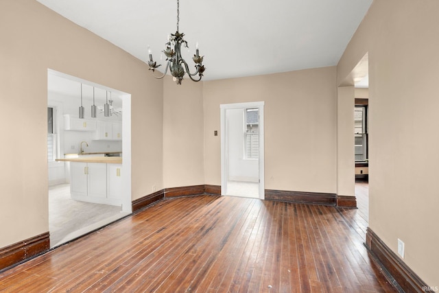 spare room featuring hardwood / wood-style floors, a chandelier, and sink