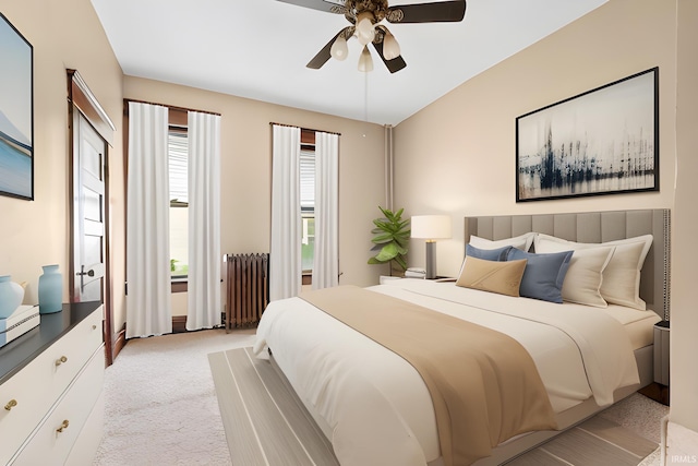 carpeted bedroom with radiator and ceiling fan