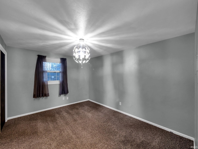 spare room featuring carpet and an inviting chandelier