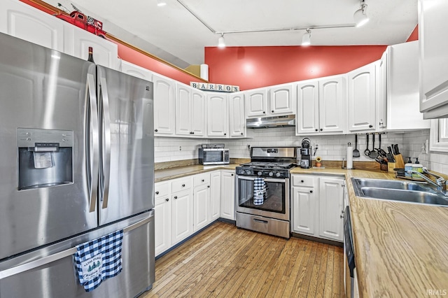 kitchen featuring white cabinets, backsplash, and stainless steel appliances