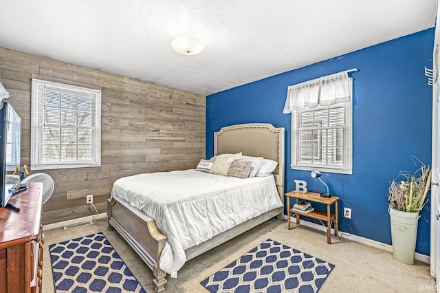 bedroom featuring carpet floors and wooden walls