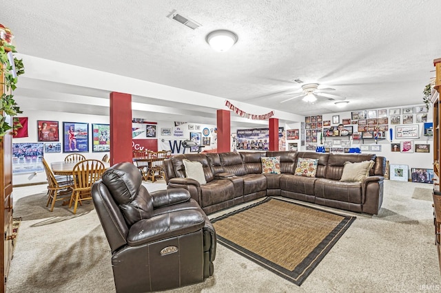 living room with carpet flooring, ceiling fan, and a textured ceiling