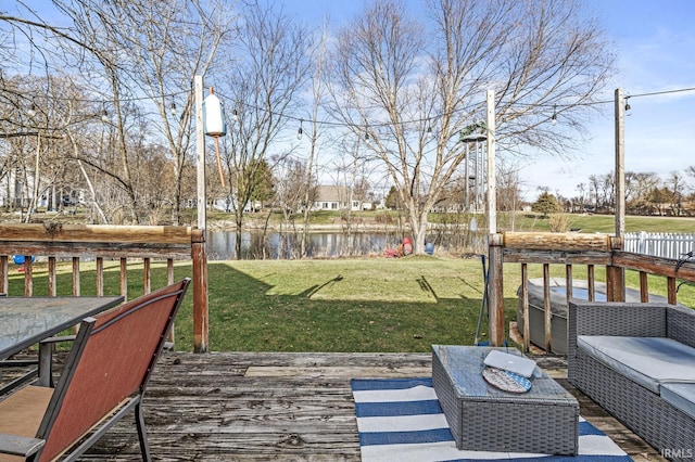 wooden terrace with a water view and a yard