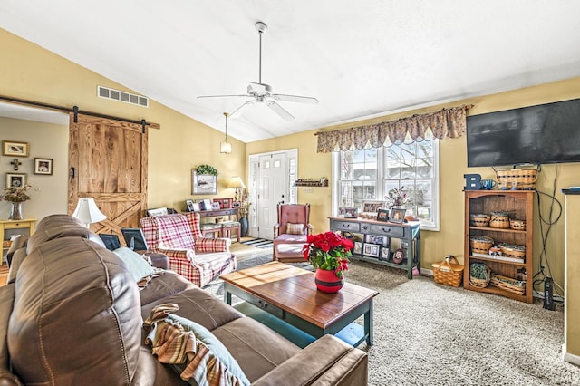 carpeted living room with a barn door, vaulted ceiling, and ceiling fan