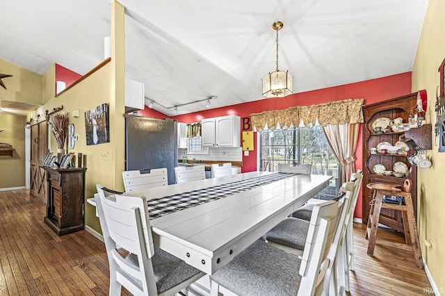 dining area with rail lighting and light wood-type flooring