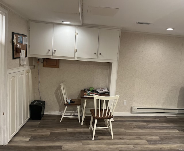 dining space featuring dark hardwood / wood-style flooring, a baseboard heating unit, and ornamental molding