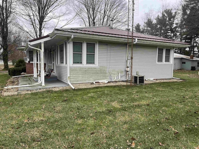 view of side of property featuring a yard and central air condition unit