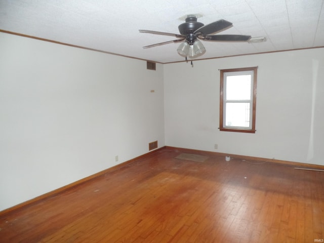 spare room with ceiling fan, crown molding, and hardwood / wood-style flooring