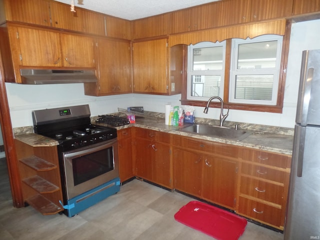 kitchen with a textured ceiling, sink, and stainless steel appliances