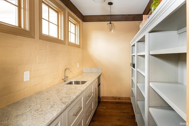 kitchen with light stone countertops, decorative backsplash, sink, decorative light fixtures, and dark hardwood / wood-style floors