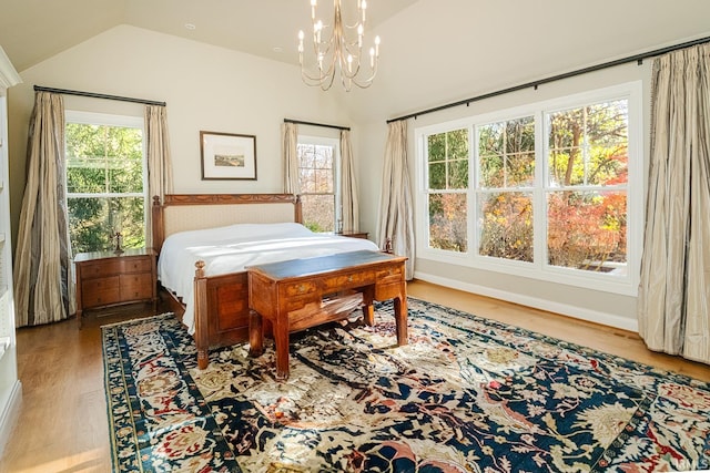 bedroom with light hardwood / wood-style floors, multiple windows, and lofted ceiling