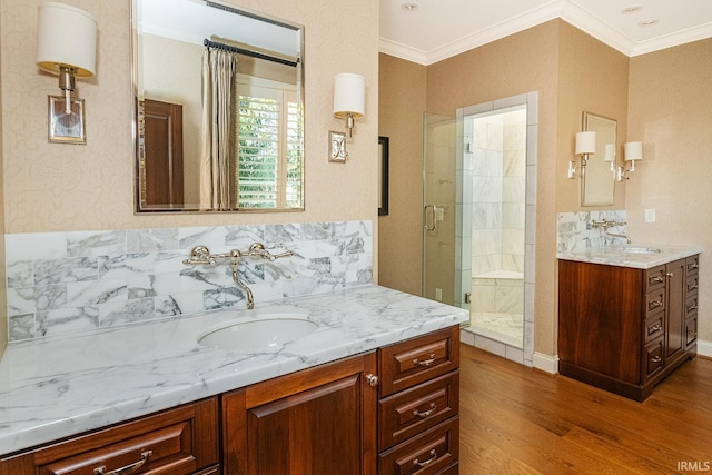 bathroom with hardwood / wood-style floors, vanity, a shower with shower door, and ornamental molding