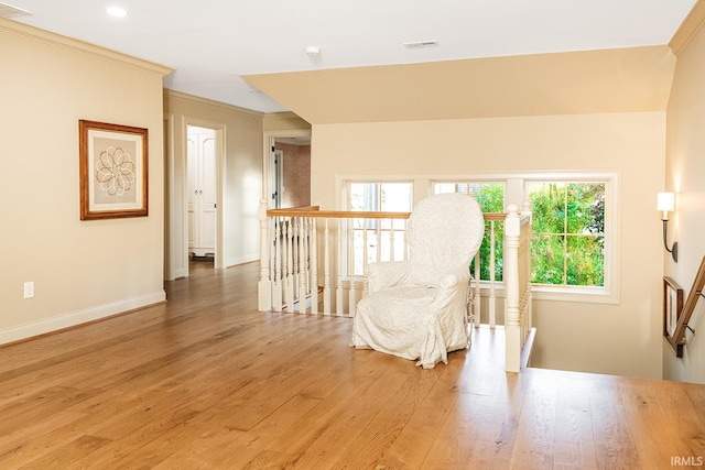 living area with hardwood / wood-style floors, plenty of natural light, and crown molding