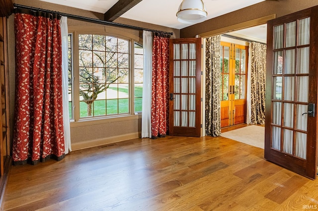 interior space with beamed ceiling, french doors, and hardwood / wood-style flooring