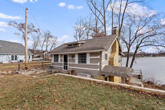 view of front of home with a front lawn and a water view