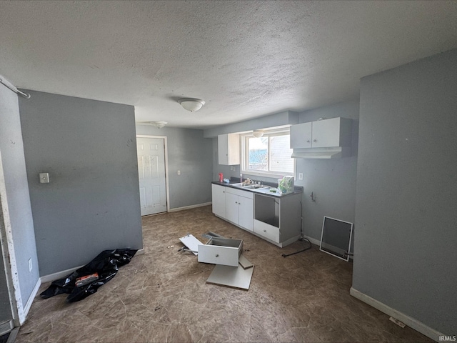 kitchen featuring white cabinets, sink, and a textured ceiling