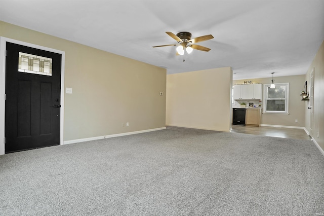 unfurnished living room with ceiling fan and light colored carpet