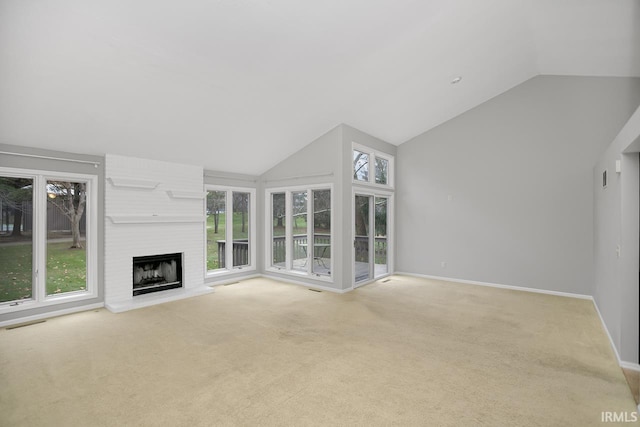 unfurnished living room featuring a wealth of natural light, carpet, and a brick fireplace