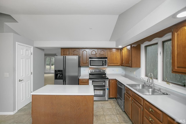 kitchen featuring a center island, stainless steel appliances, lofted ceiling, and sink