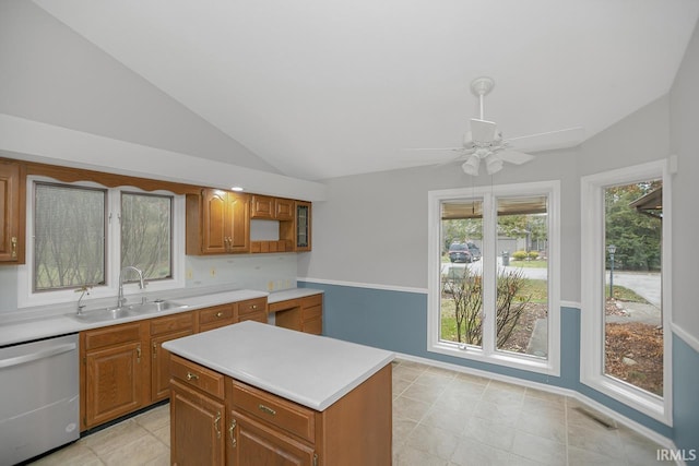 kitchen featuring dishwasher, a kitchen island, lofted ceiling, and sink