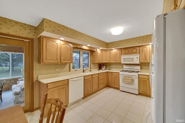 kitchen featuring light tile patterned flooring, white appliances, and sink