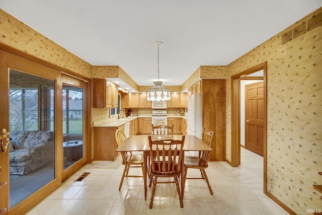 tiled dining area with sink and a notable chandelier