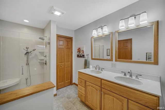 bathroom with vanity and a shower with door