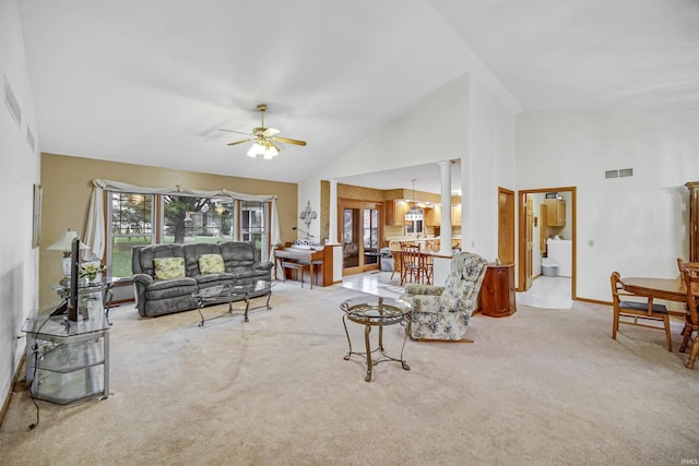 carpeted living room with washer / clothes dryer, high vaulted ceiling, ceiling fan, and decorative columns