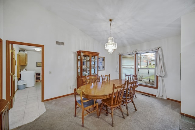 carpeted dining room featuring washer / clothes dryer, lofted ceiling, and a notable chandelier