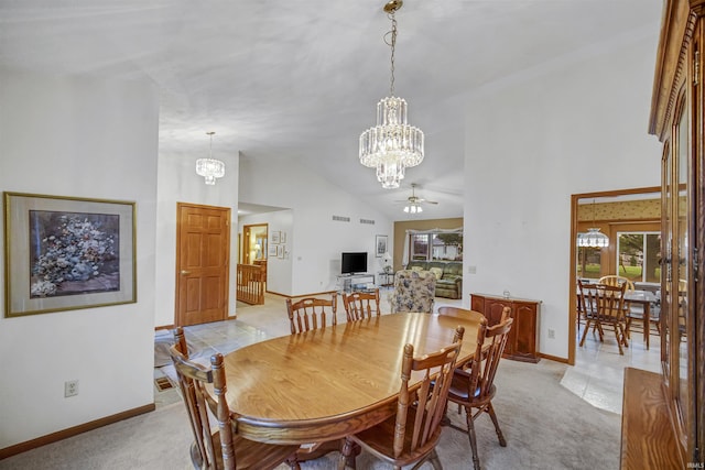 carpeted dining area with ceiling fan with notable chandelier and high vaulted ceiling