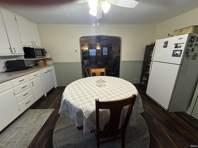 kitchen featuring ceiling fan, white cabinetry, dark hardwood / wood-style flooring, and white appliances