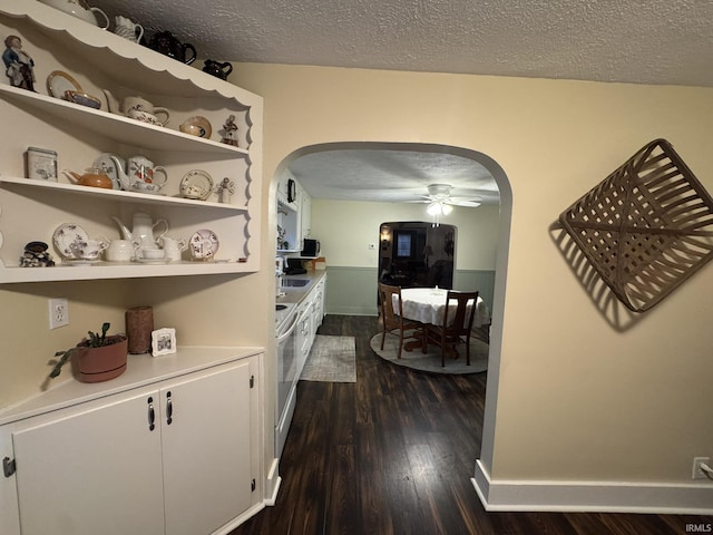 hallway featuring sink, dark wood-type flooring, and a textured ceiling