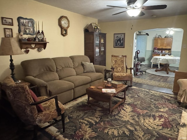 living room featuring wood-type flooring and ceiling fan