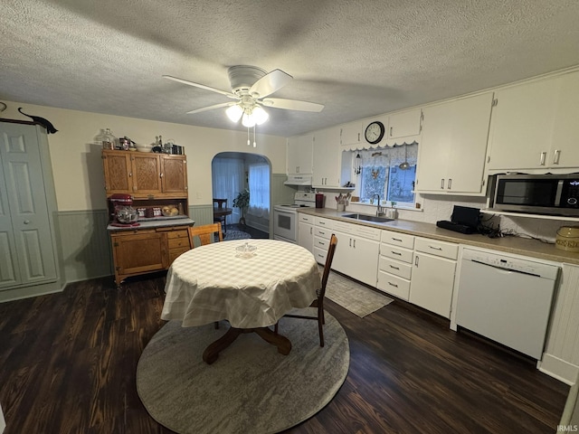 kitchen featuring sink, dark hardwood / wood-style flooring, a textured ceiling, white appliances, and white cabinets