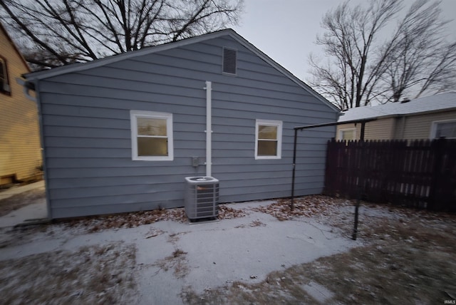 snow covered property featuring central AC unit